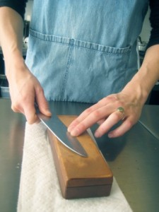A picture of a whetstone sharpener and a knife