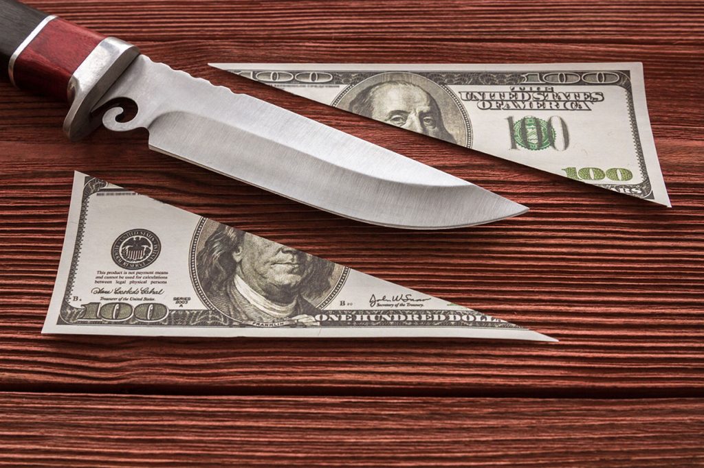 Knife cutting a $100 bill