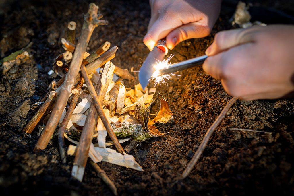 Outdoors making fire by flint