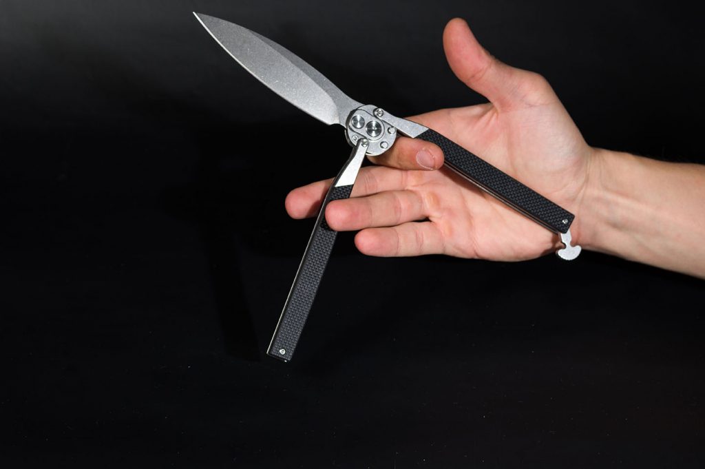 Balisong knife in the palm of your hand. Trick with a knife.