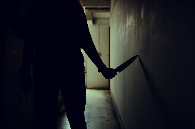 The shadow of a female murderer stood terrifyingly holding a kni